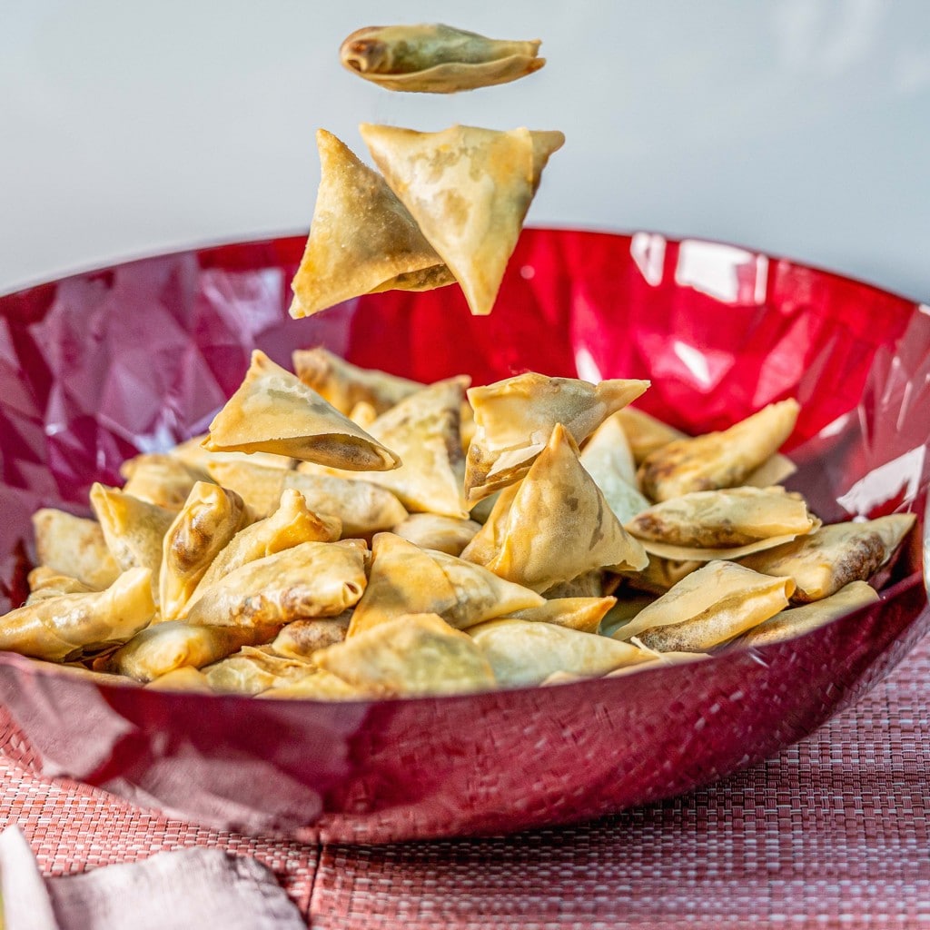 samoussa boeuf au cury présentés artistiquement en lévitation au-dessus d'un bol