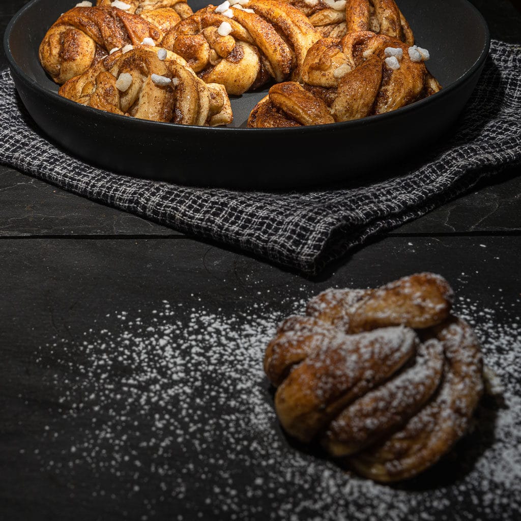 Plat de kanelbullar, des brioches suédoises à la cannelle décorées de sucre glace