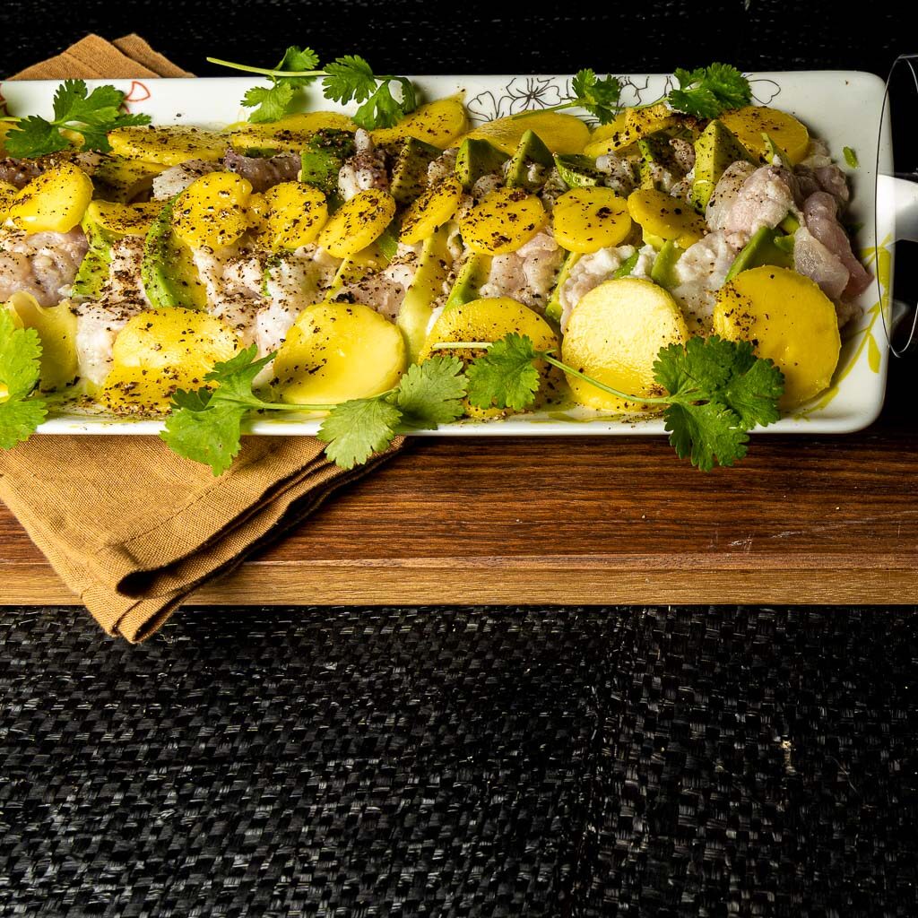 ceviche de poisson, de la daurade, présentée avec de la mangue en rondelles et des tranches d'avocat en alternance