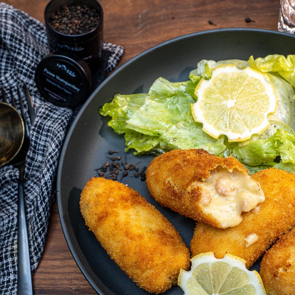 assiette de croquettes grises et de salades vertes avec un pot de voatsiperifery Spyceez